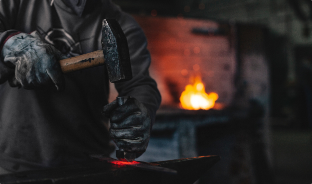 Imagem de um homem forjando uma faca artesanal
